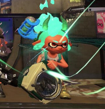 A green inkling girl from the game Splatoon 2, holding a weapon that looks like a washing machine. She faces slightly right.